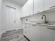 Laundry room with white cabinets and gray flooring at 14681 Keystone Blvd, Port Charlotte, FL 33981