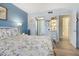 Bedroom with floral bedding, wood-look floors, and view into bathroom at 1515 Forrest Nelson Blvd # A 202, Port Charlotte, FL 33952