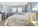 Bedroom with floral bedding, gray armchair, and wood-look floors at 1515 Forrest Nelson Blvd # A 202, Port Charlotte, FL 33952