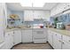 Bright kitchen with white cabinets, wood-look floors, and modern appliances at 1515 Forrest Nelson Blvd # A 202, Port Charlotte, FL 33952
