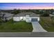 Aerial view of a single-story home with a two-car garage and landscaped lawn at 15384 Hennipen Cir, Port Charlotte, FL 33981