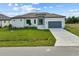 Single-story home with gray garage door, light-colored exterior, and a neatly manicured lawn at 15384 Hennipen Cir, Port Charlotte, FL 33981