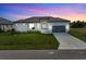 Modern single-story home with tile roof and attached garage at dusk at 15384 Hennipen Cir, Port Charlotte, FL 33981