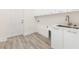 Bright laundry room with white cabinets and vinyl flooring at 15384 Hennipen Cir, Port Charlotte, FL 33981
