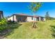 Screened patio and grassy backyard with a young tree at 19584 Fishhawk Trl, Venice, FL 34293