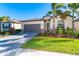 Single-story home with gray garage door, landscaping, and paver driveway at 19584 Fishhawk Trl, Venice, FL 34293