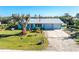 Single-story home with a metal roof, large yard, and American flag at 2495 Tenth St, Englewood, FL 34224