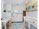 Bathroom with white vanity, seashell rug, and beach themed art at 2495 Tenth St, Englewood, FL 34224