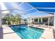 Inviting pool area with screened enclosure, lounge chairs, and lush landscaping at 2495 Tenth St, Englewood, FL 34224