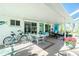 Screened porch with table, chairs, and bikes at 2495 Tenth St, Englewood, FL 34224