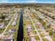 Aerial view of a canal running through a neighborhood, showcasing various houses and landscaping at 256 Mark Twain Ln, Rotonda West, FL 33947