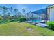Landscaped backyard with pool and screened enclosure at 26852 Faldo Ln, Englewood, FL 34223