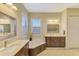 Primary bathroom with corner soaking tub and double vanity at 26852 Faldo Ln, Englewood, FL 34223