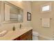 Small bathroom boasts a vanity with a quartz countertop, toilet and shower/tub combo at 26852 Faldo Ln, Englewood, FL 34223