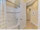 Bathroom with tub, shower, and door leading to hallway at 26852 Faldo Ln, Englewood, FL 34223
