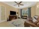 Spacious home office with ceiling fan, leather recliner, and built-in shelving at 26852 Faldo Ln, Englewood, FL 34223