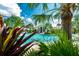 Tropical pool area with lush landscaping and a view of the clubhouse at 26852 Faldo Ln, Englewood, FL 34223