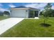 White house with a two-car garage and well-maintained lawn at 30072 Alder Rd, Punta Gorda, FL 33982