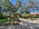 House driveway with mature trees and landscaping at 3117 Silkwood Ln, Port Charlotte, FL 33953