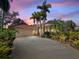 Single-story home with tile roof, palm trees, and a long driveway at 3117 Silkwood Ln, Port Charlotte, FL 33953