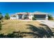 Single story home with gray garage door and landscaping at 32 Oakland Hills Ct, Rotonda West, FL 33947