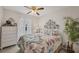 Cozy bedroom with a floral patterned quilt, ceiling fan, white dresser, and decorative accents with plenty of natural light at 4036 Elvington Rd, Port Charlotte, FL 33981