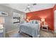Guest bedroom with a queen-size bed and terracotta accent wall at 520 Pine Hollow Cir # 520, Englewood, FL 34223