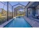 Long pool with spa, screened enclosure, and patio furniture at 6096 Bowie Ln, Englewood, FL 34224