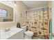 Clean bathroom with white vanity, toilet and a beach-themed shower curtain at 6358 Granger Rd, Port Charlotte, FL 33981
