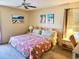 Bedroom with a floral bedspread, ceiling fan, and beach-themed wall decorations at 6358 Granger Rd, Port Charlotte, FL 33981