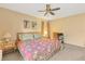 Cozy bedroom featuring a floral comforter, ceiling fan, and desk setup near the window at 6358 Granger Rd, Port Charlotte, FL 33981