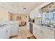 Well-lit kitchen featuring white cabinetry, granite counters, and a stainless steel sink at 6358 Granger Rd, Port Charlotte, FL 33981