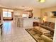 Open-concept living room featuring tile floors, a breakfast bar, and comfortable seating arrangements at 6358 Granger Rd, Port Charlotte, FL 33981