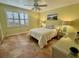 Comfortable bedroom with a queen-size bed, tiled floors, and window shutters at 72 Boundary Blvd # 229, Rotonda West, FL 33947