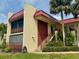 Condo building exterior with red roof, light-yellow walls, and landscaping at 72 Boundary Blvd # 229, Rotonda West, FL 33947