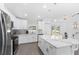 Modern kitchen with white cabinets, stainless steel appliances, granite countertops and an island at 7320 Freeberg Cir, Port Charlotte, FL 33981