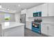 Bright kitchen with white cabinets, stainless steel appliances, a large island, and modern finishes at 7320 Freeberg Cir, Port Charlotte, FL 33981