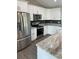 A bright kitchen featuring white cabinets, stainless steel appliances, and gray backsplash at 7320 Freeberg Cir, Port Charlotte, FL 33981