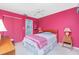 Bright bedroom with pink walls, wooden bed frame and ceiling fan at 7346 Regina Dr, Englewood, FL 34224