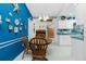 Bright dining room with a round wooden table, white cabinets, and blue walls at 7346 Regina Dr, Englewood, FL 34224