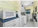 Laundry room with washer, dryer, microwave and storage at 7346 Regina Dr, Englewood, FL 34224