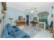 Living room features a wooden desk, blue sofa, and a ceiling fan at 7346 Regina Dr, Englewood, FL 34224