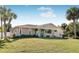 Single story home with light beige siding and a teal front door surrounded by palm trees at 9487 Prospect Ave, Englewood, FL 34224