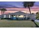 Inviting home at sunset, showcasing the front yard and landscaping at 9487 Prospect Ave, Englewood, FL 34224