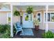 Welcoming front porch featuring hanging plants and blue chairs at 9487 Prospect Ave, Englewood, FL 34224