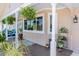 Covered porch with hanging plants and seating area at 9487 Prospect Ave, Englewood, FL 34224
