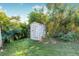 Grey storage shed nestled within a tropical garden setting at 9487 Prospect Ave, Englewood, FL 34224