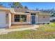 Tan house with a white garage door and landscaped lawn at 3258 N Biscayne Dr, North Port, FL 34291