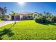 House with a large yard, palm trees, and a three-car garage at 109 Bonita Dr, Rotonda West, FL 33947