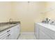 Laundry room with side-by-side washer and dryer and granite countertop at 109 Bonita Dr, Rotonda West, FL 33947